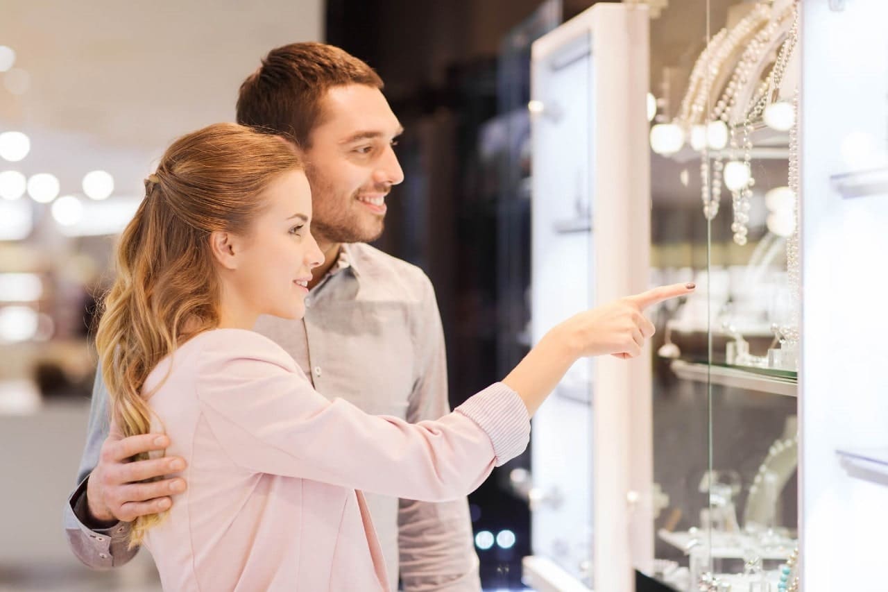 A couple looking at necklaces on display in a jewelry store