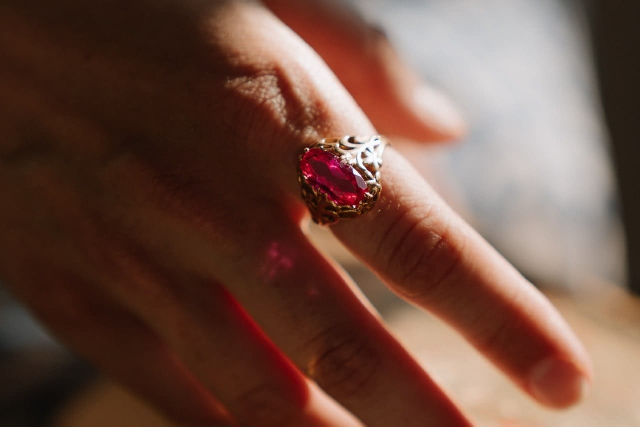 A woman with manicured nails wears a vintage sterling silver pink topaz ring
