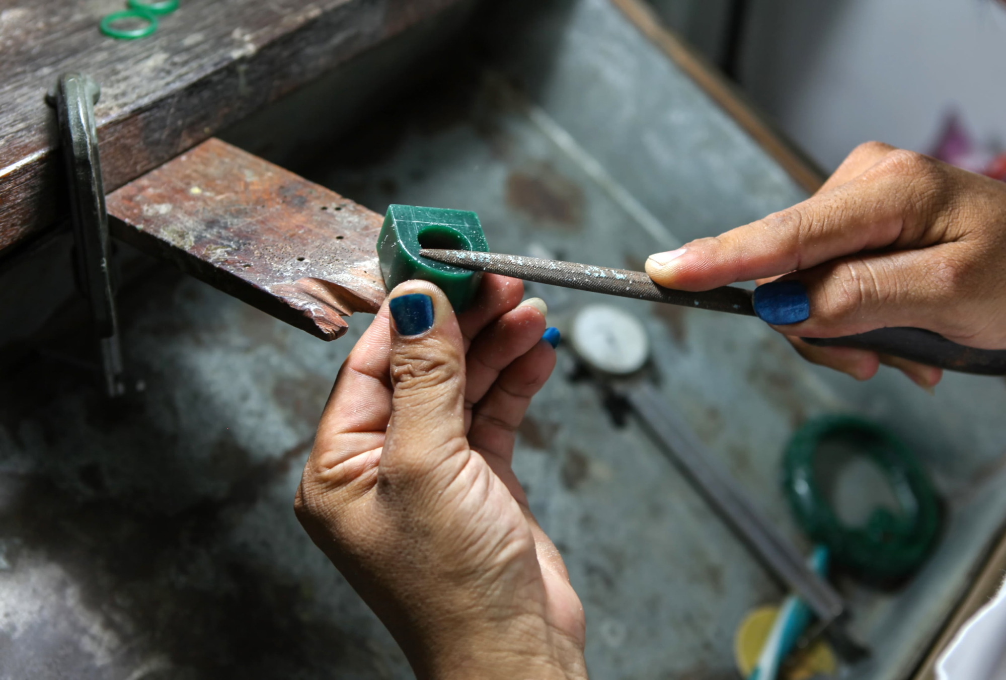A jeweler shapes a piece of wax to make a model of a custom jewelry design