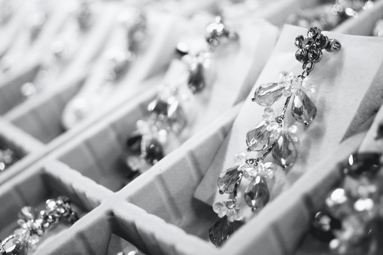 black and white photo of earrings sorted into a jewelry case