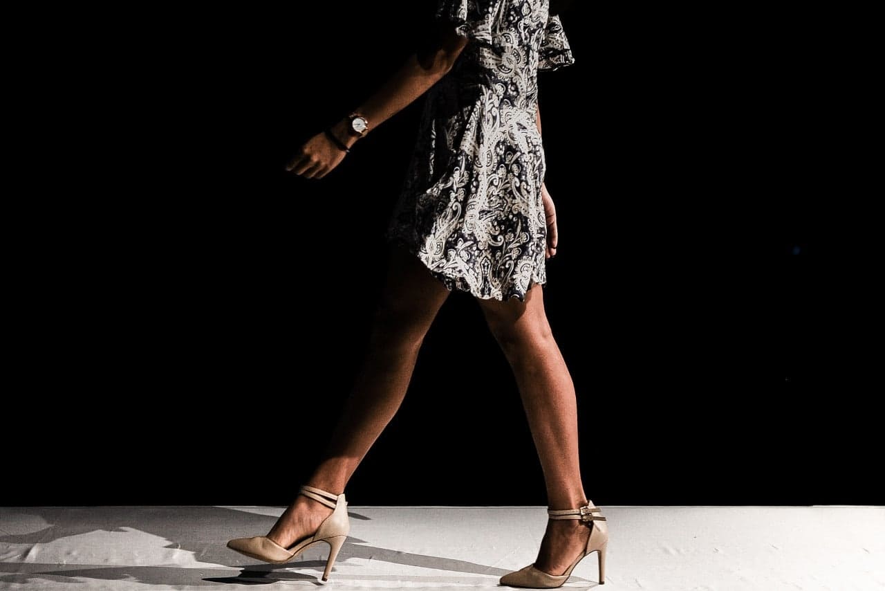 A standing woman in heels wearing watch