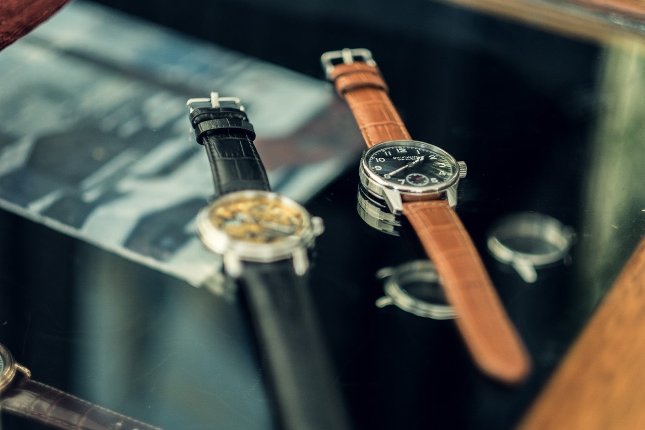 Two watches with leather straps.