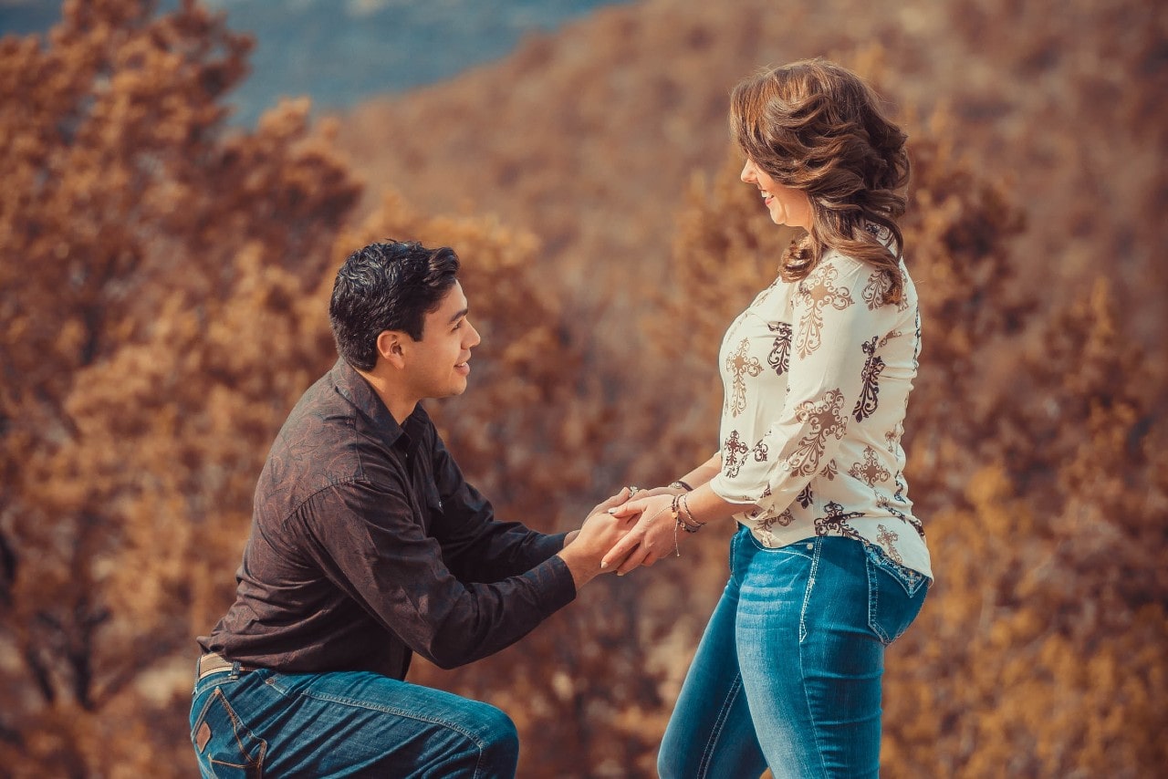 A man proposes to his girlfriend during a casual autumn hike in the woods