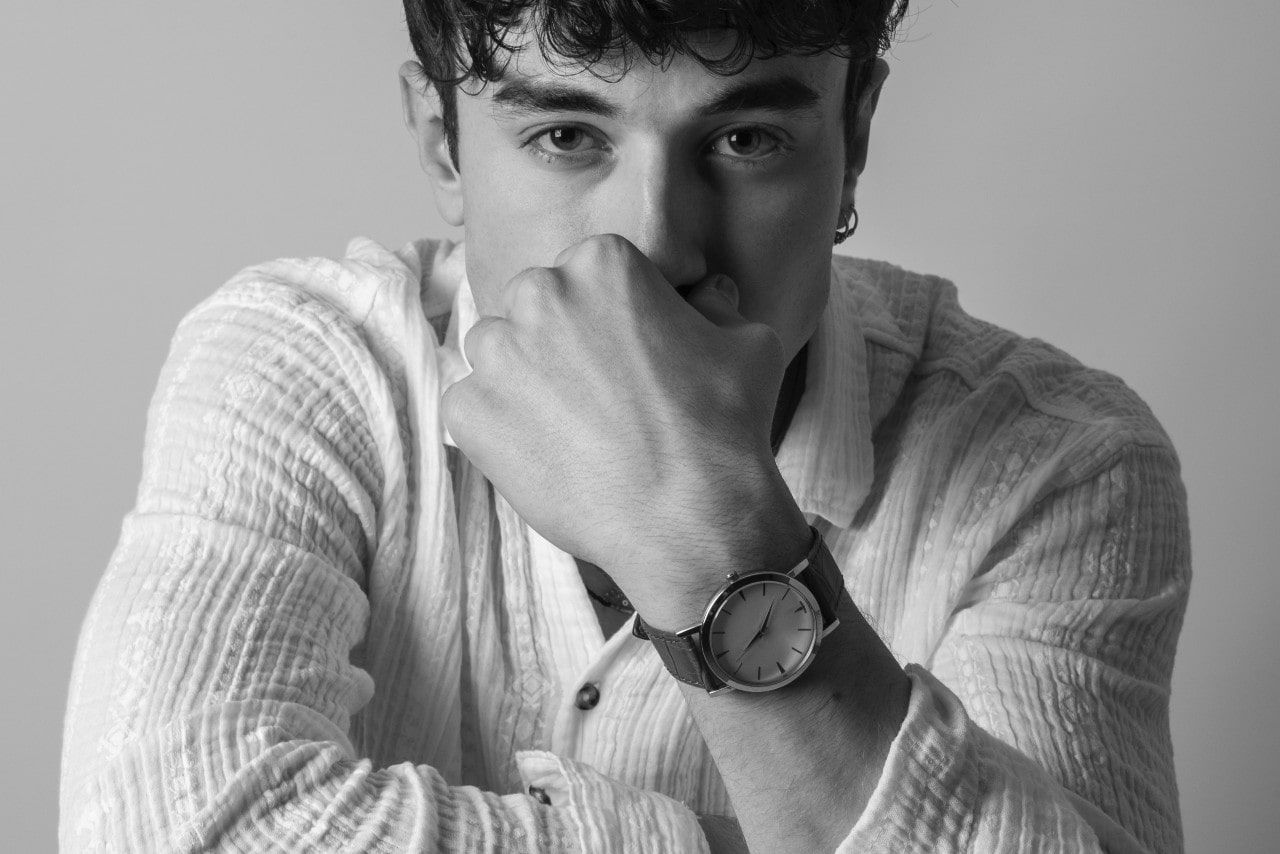 black and white image of a man wearing a luxury watch